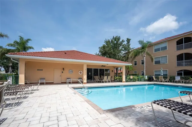 a view of a house with pool and chairs