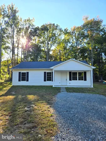 a view of a yard in front of a house with large trees