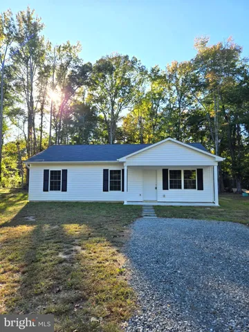 a view of a yard in front of a house with large trees