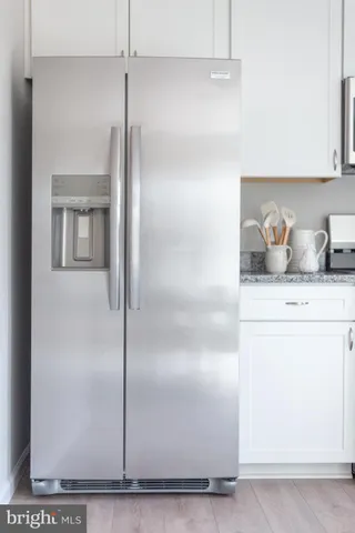 a kitchen with granite countertop a refrigerator sink and cabinets