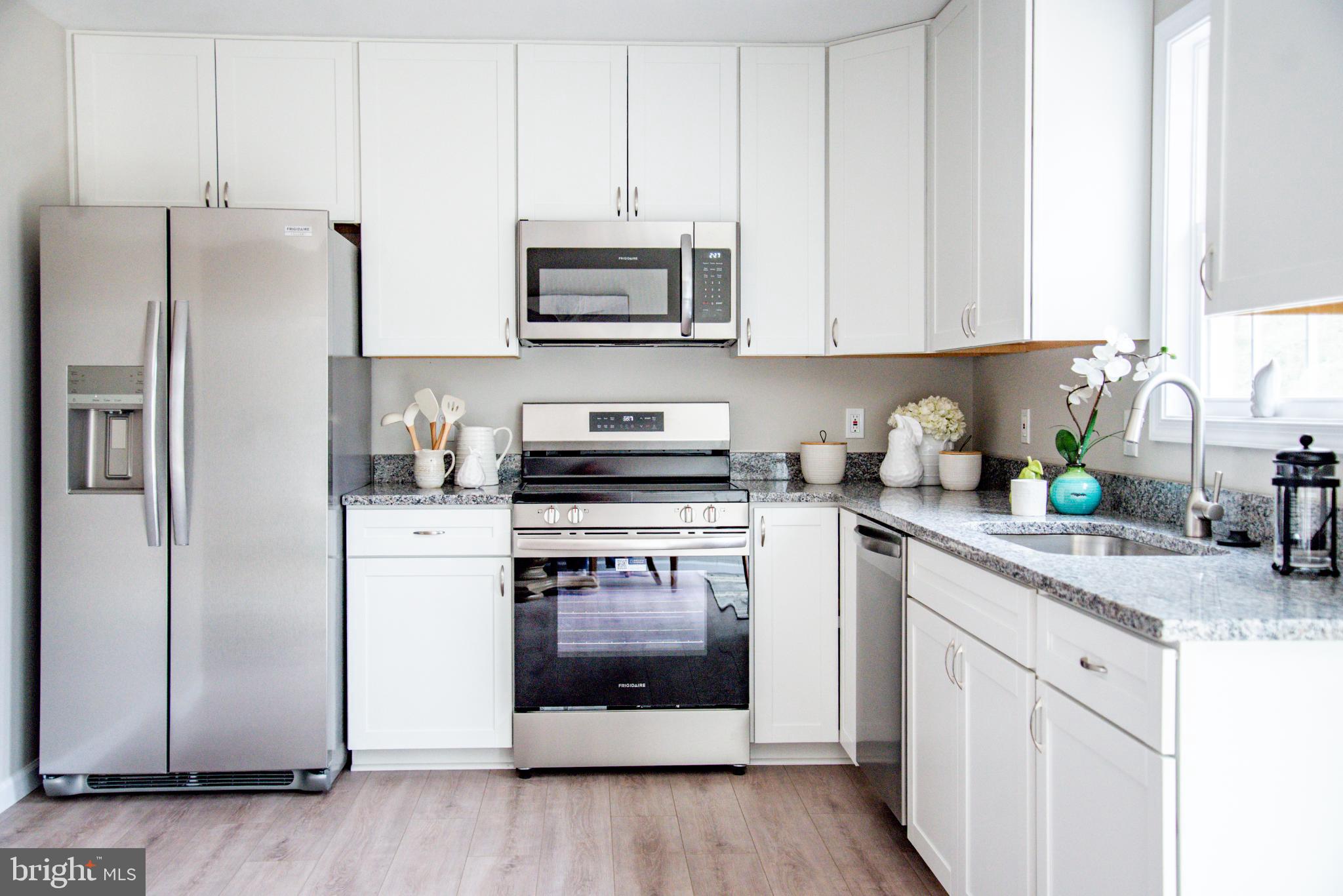 227 Forest Grove Road Colonial Beach, VA 22443 - Photo 8 of 22 a kitchen with stainless steel appliances granite countertop a refrigerator sink and microwave