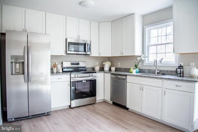a kitchen with stainless steel appliances granite countertop a refrigerator sink and microwave