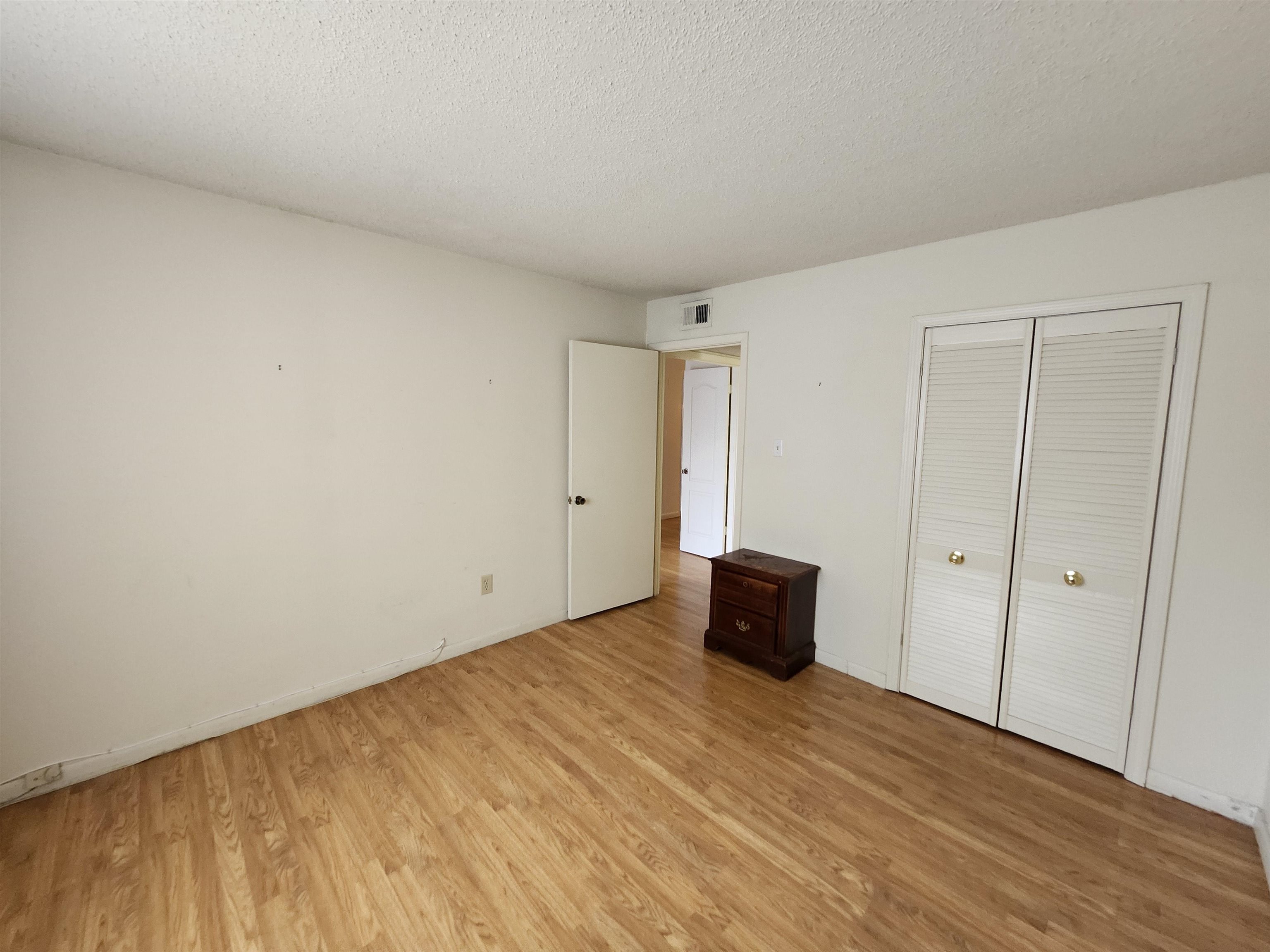 4776 Audubon View Circle, Unit 1 Memphis, TN 38117 - Photo 16 of 16 Unfurnished bedroom featuring light wood-style flooring, a textured ceiling, and a closet