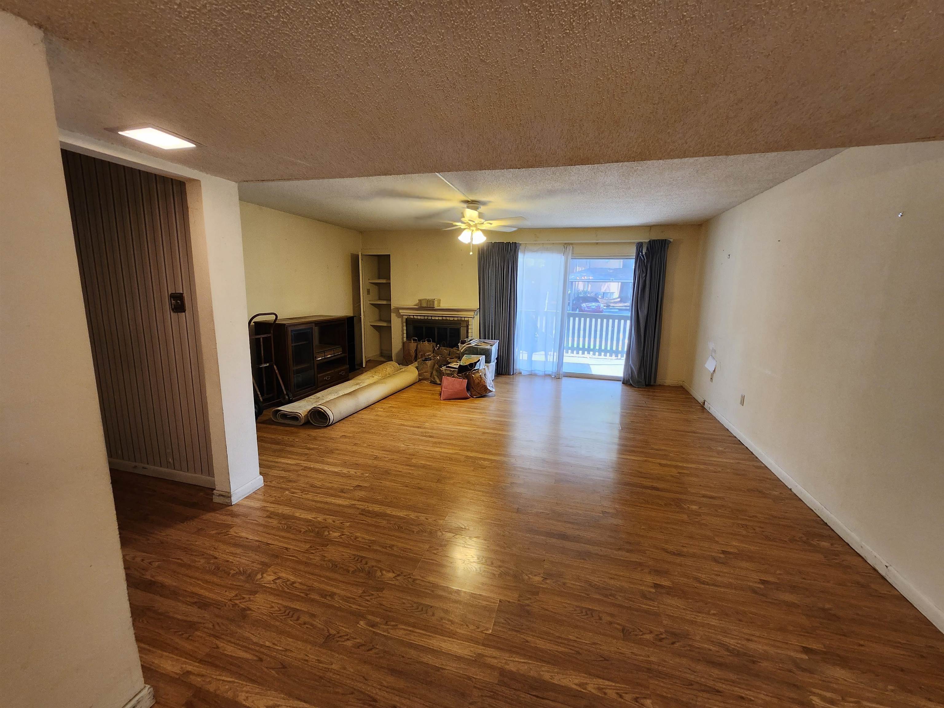4776 Audubon View Circle, Unit 1 Memphis, TN 38117 - Photo 7 of 16 Unfurnished living room with a fireplace, a textured ceiling, and wood finished floors