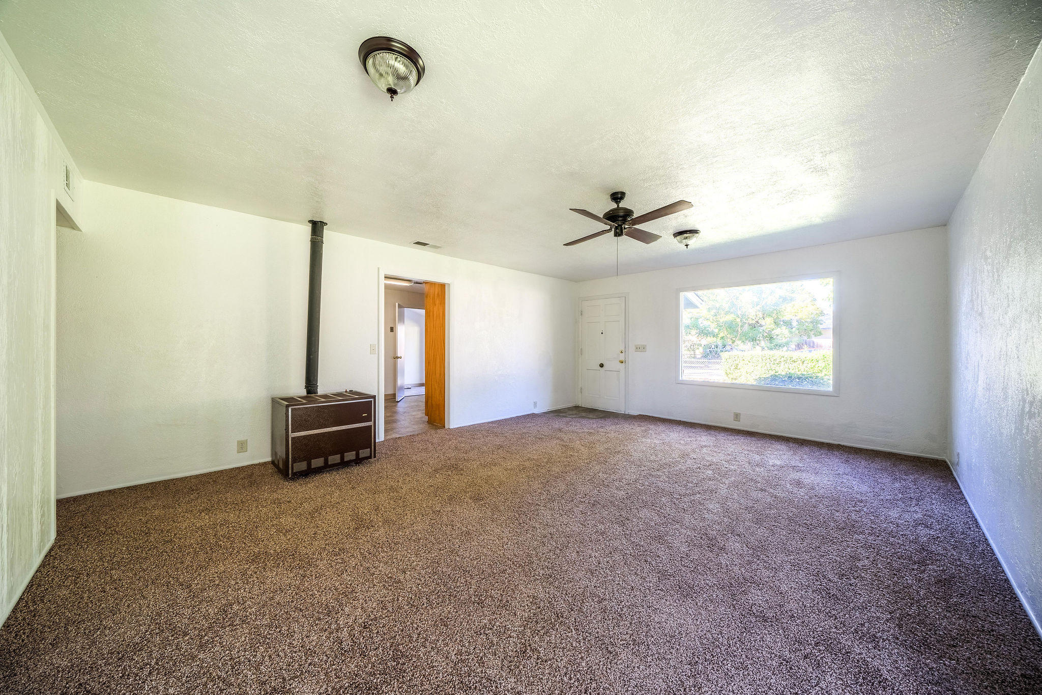 1138 Layton Road Redding, CA 96002 - Photo 6 of 22 an empty room with windows and fan