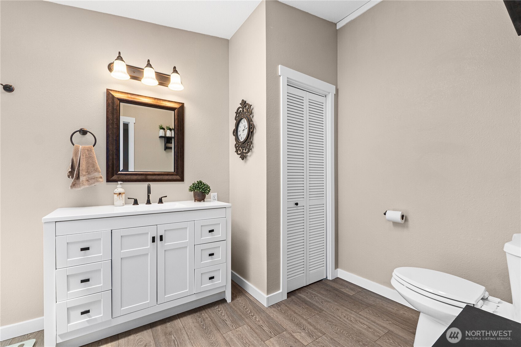 4562 Lessig Road, Unit A Hunters, WA 99137 - Photo 12 of 34 a bathroom with a toilet a sink a mirror and wooden floor