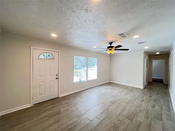 wooden floor in an empty room with a window
