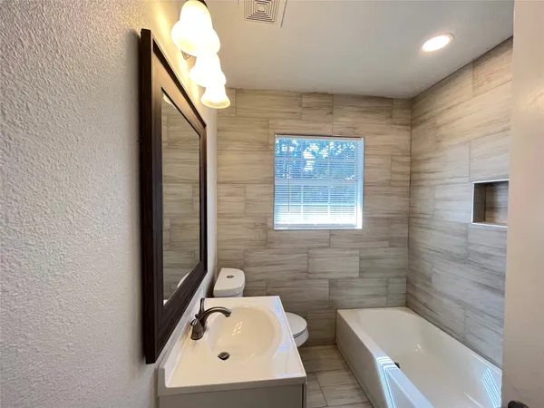 a bathroom with a bathtub sink and toilet