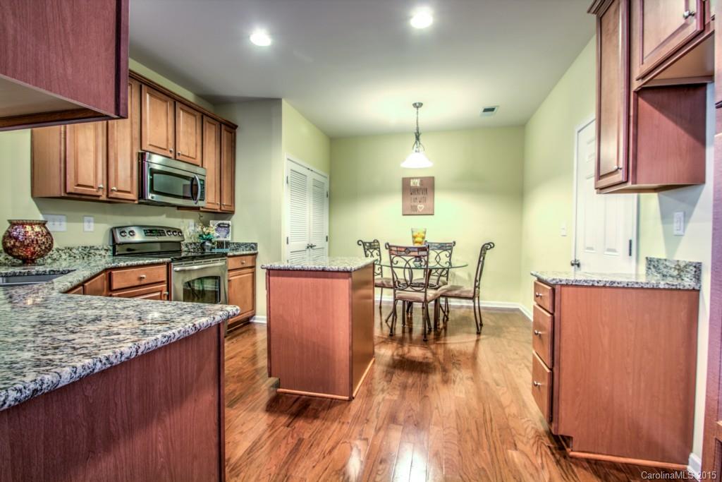 211 Chartwell Lane, Unit 211 Tega Cay, SC 29708 - Photo 3 of 19 a kitchen with stainless steel appliances granite countertop sink stove top oven and cabinets
