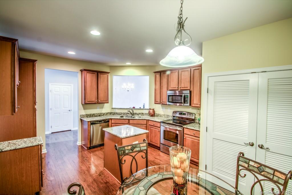 211 Chartwell Lane, Unit 211 Tega Cay, SC 29708 - Photo 4 of 19 a kitchen with stainless steel appliances granite countertop a stove a sink dishwasher and a refrigerator with wooden floor