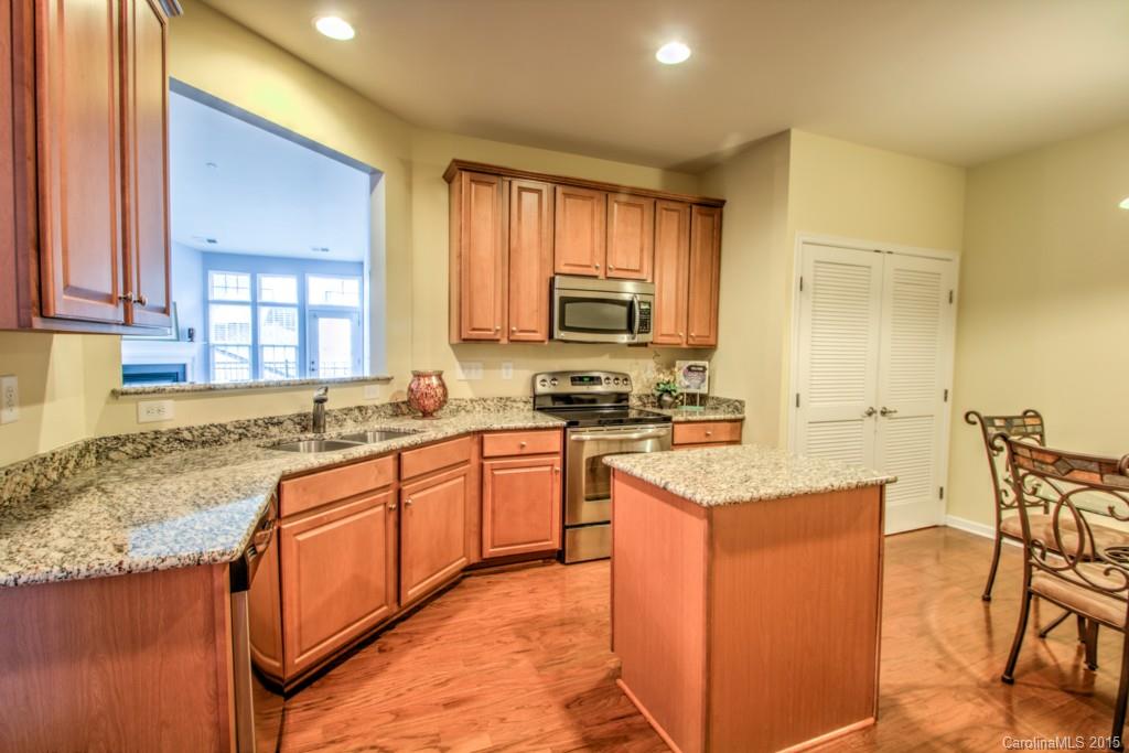 211 Chartwell Lane, Unit 211 Tega Cay, SC 29708 - Photo 5 of 19 a kitchen with stainless steel appliances granite countertop wooden cabinets a sink and a stove