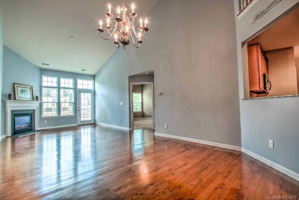 211 Chartwell Lane, Unit 211 Tega Cay, SC 29708 - Photo 6 of 19 a view of an empty room with wooden floor and a window