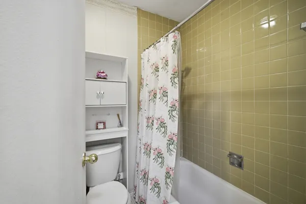 a bathroom with a toilet and shower curtain