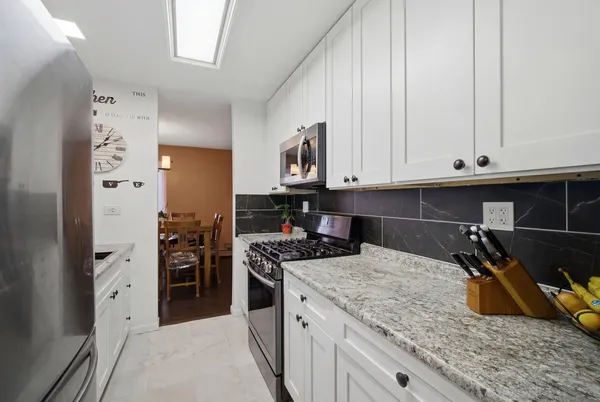 a kitchen with granite countertop a sink a stove and refrigerator