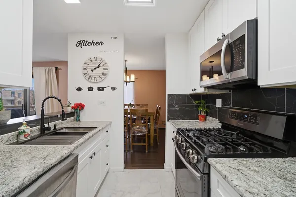 a kitchen with stainless steel appliances granite countertop a stove and a microwave