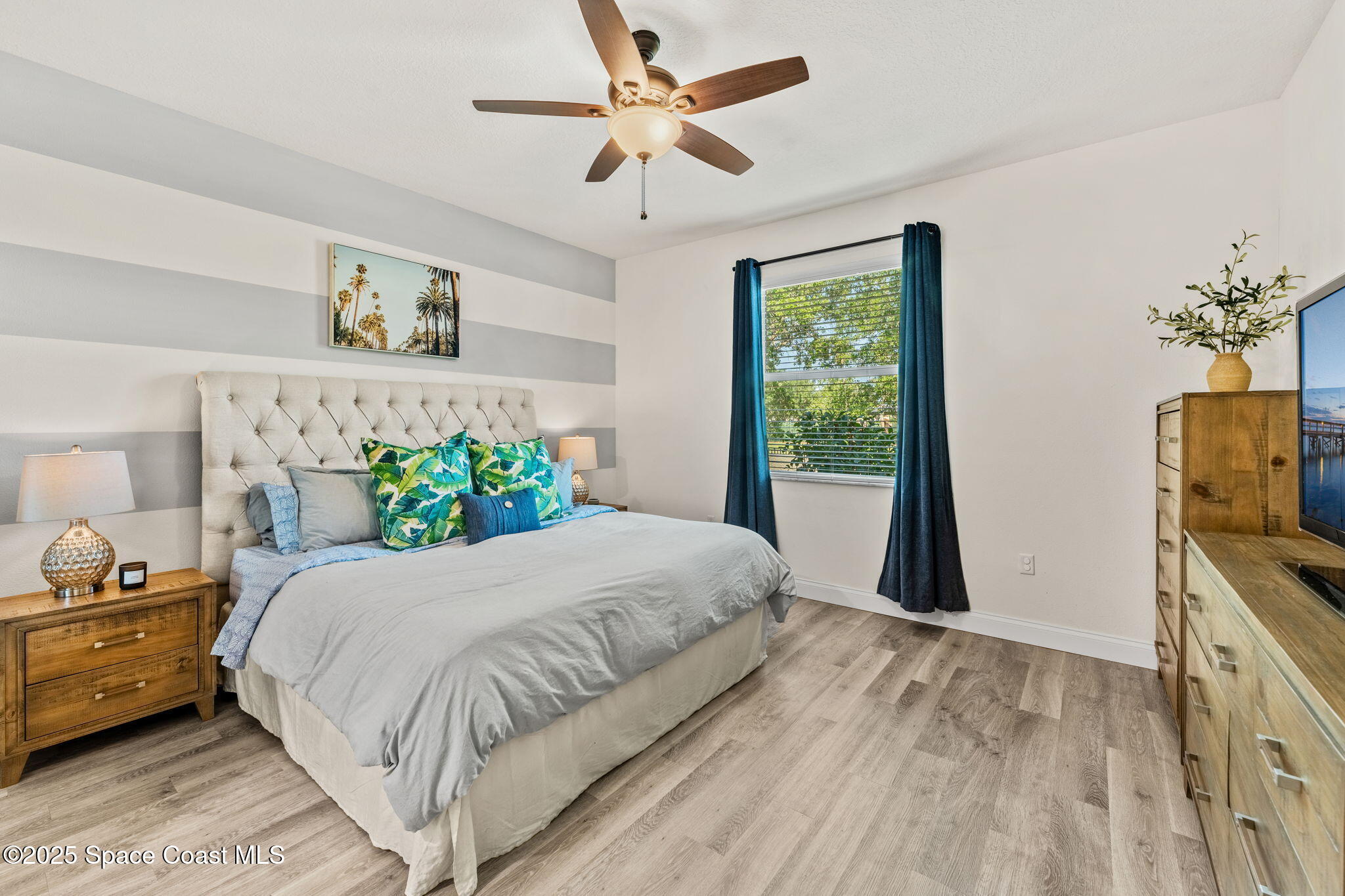5824 Trieda Drive Melbourne, FL 32940 - Photo 14 of 45 a bedroom with a bed potted plant on the dresser and a chandelier