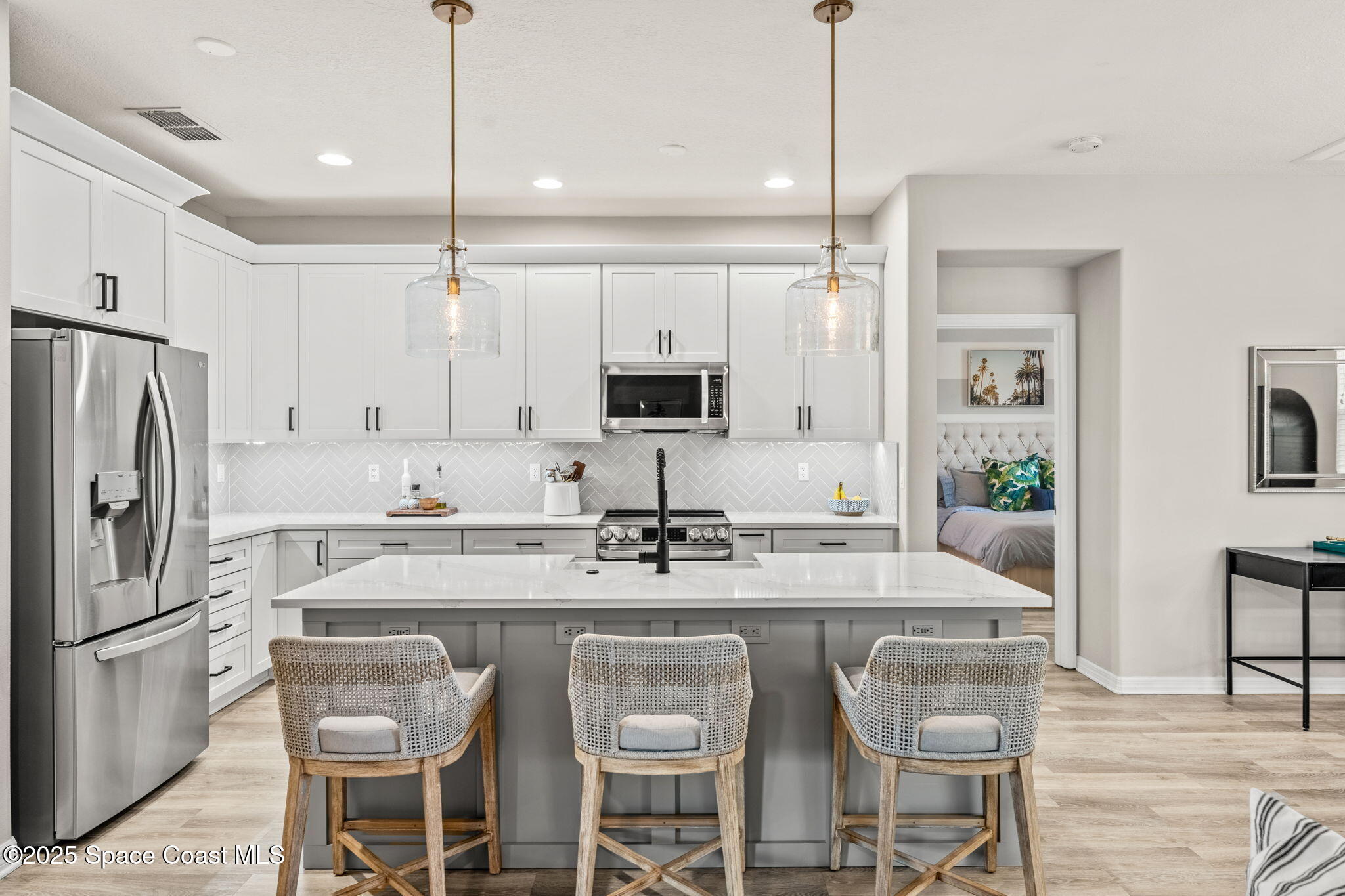 5824 Trieda Drive Melbourne, FL 32940 - Photo 2 of 45 a kitchen with stainless steel appliances granite countertop a sink a stove a refrigerator and island with wooden floor
