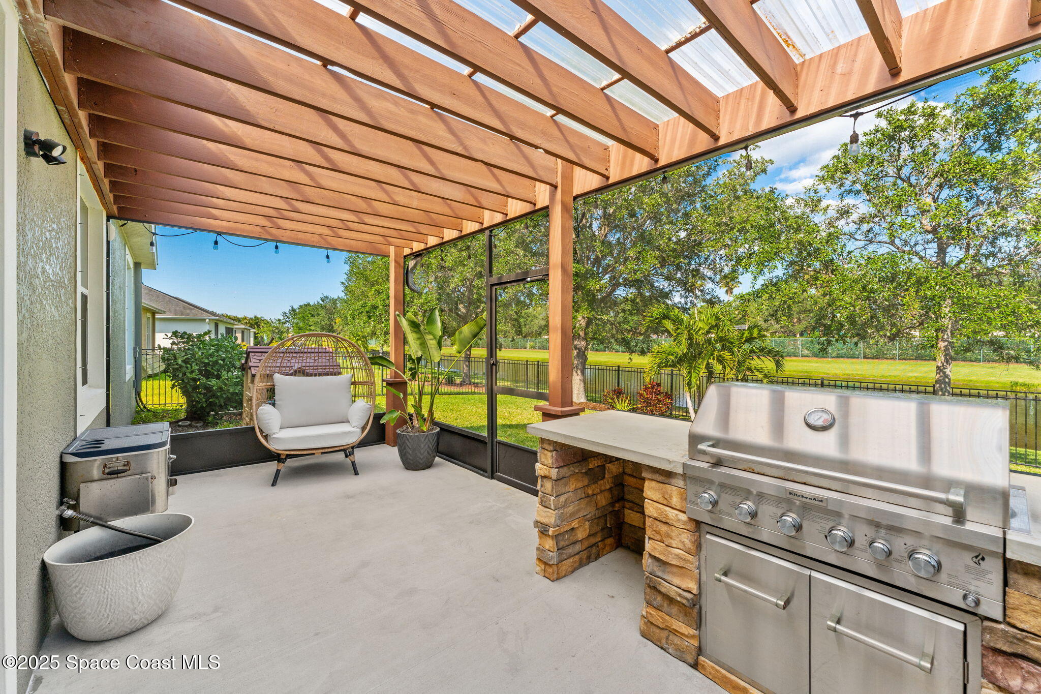 5824 Trieda Drive Melbourne, FL 32940 - Photo 25 of 45 a view of a patio with table and chairs under an umbrella