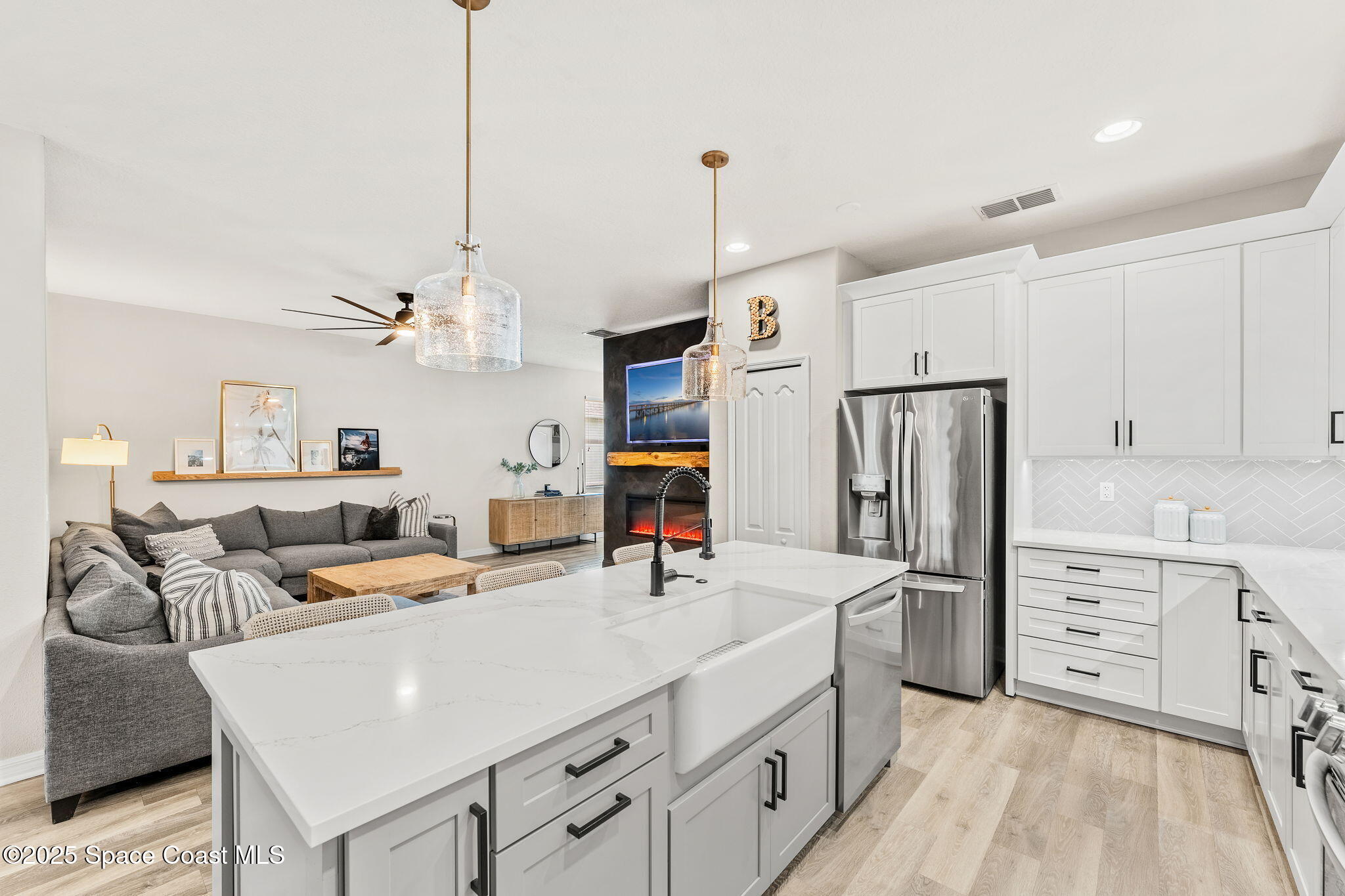 5824 Trieda Drive Melbourne, FL 32940 - Photo 7 of 45 a room with stainless steel appliances kitchen island granite countertop a refrigerator a sink dishwasher and white cabinets with wooden floor