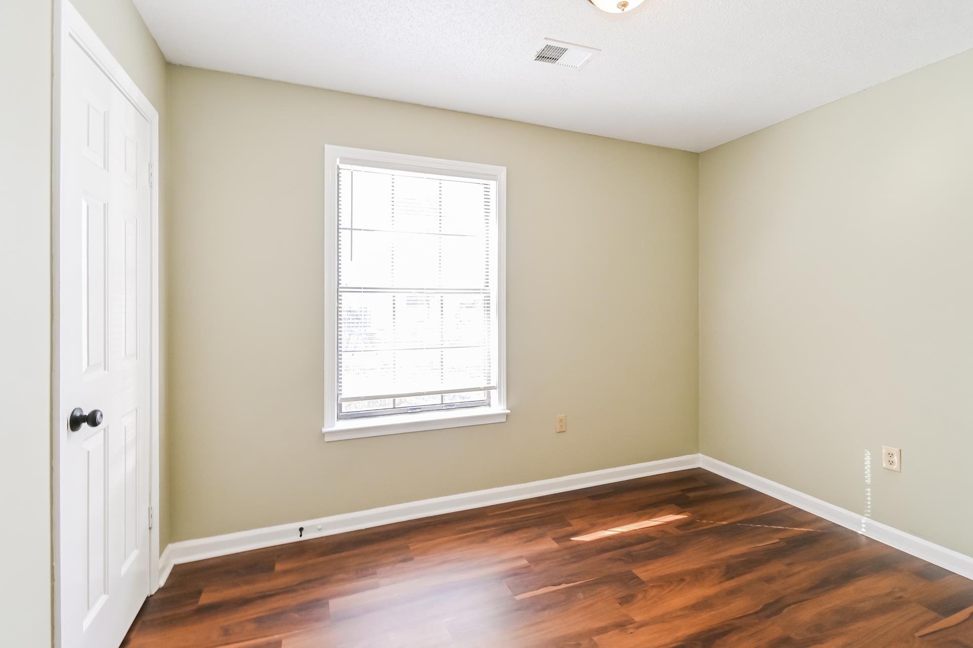 5833 South Newberry Lane Memphis, TN 38115 - Photo 13 of 16 an empty room with wooden floor and windows