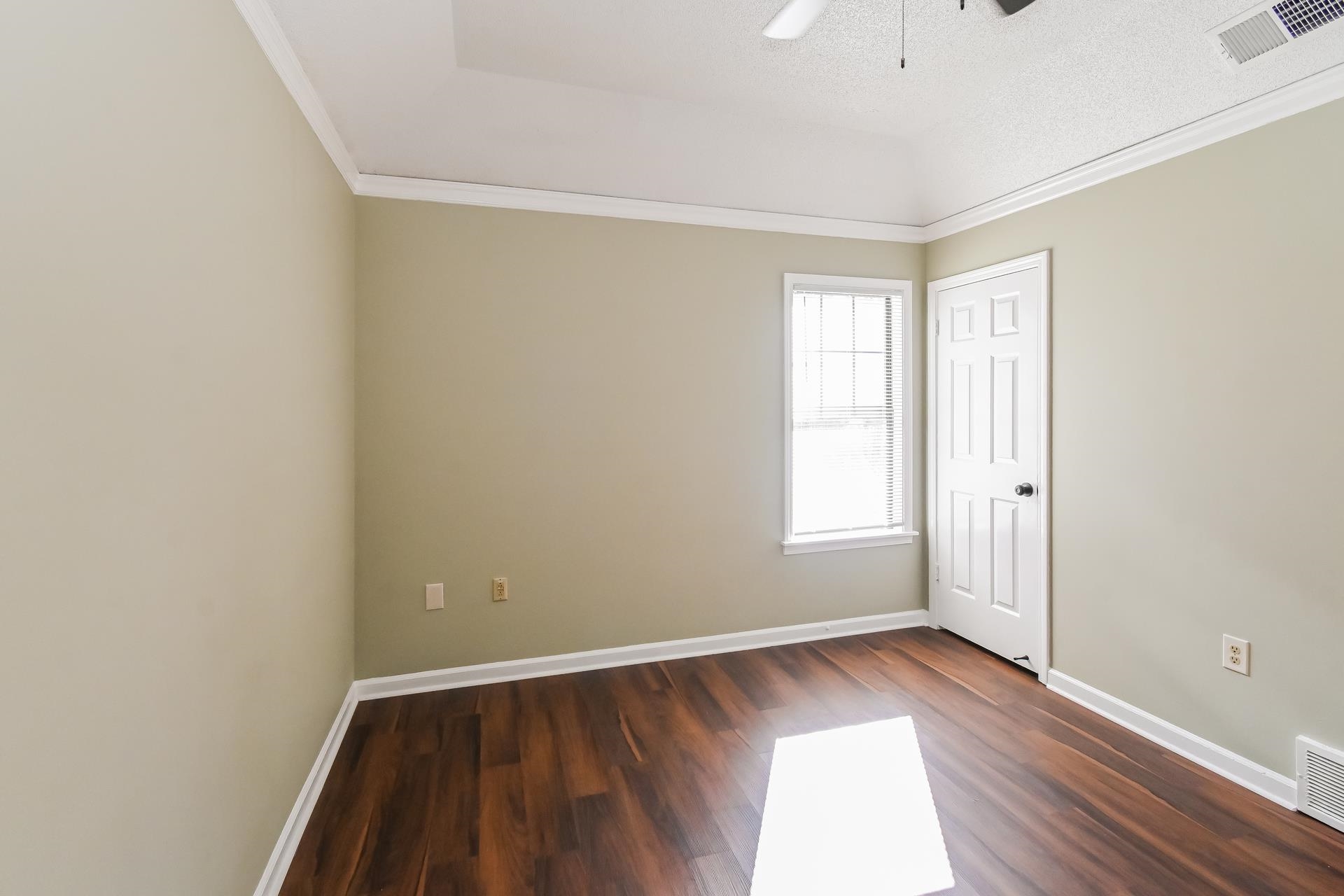 5833 South Newberry Lane Memphis, TN 38115 - Photo 9 of 16 an empty room with wooden floor and windows