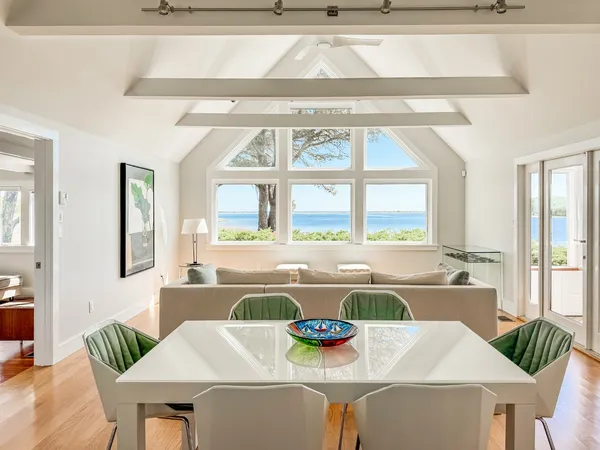 a view of a dining room with furniture a chandelier and wooden floor