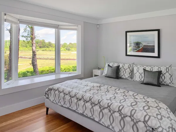 a bedroom with a bed and a large window