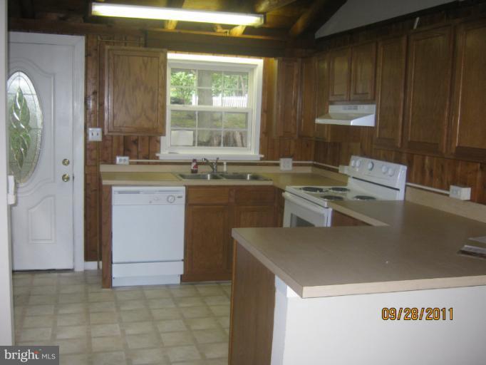447 Buffalo Road Lusby, MD 20657 - Photo 6 of 8 a kitchen with a sink a stove and cabinets