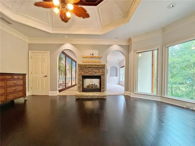 an empty room with windows and fan