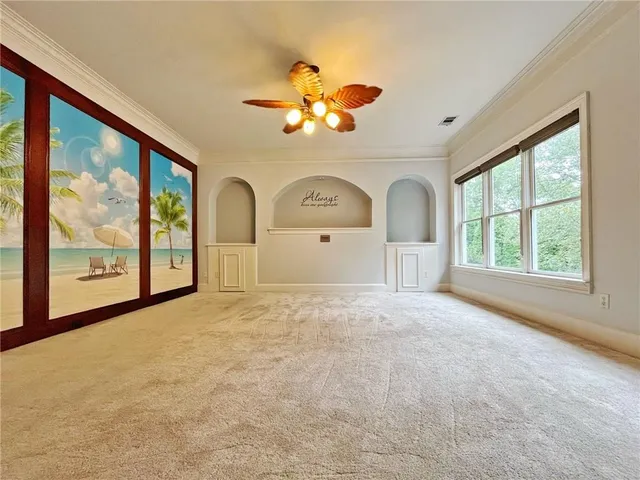 a view of empty room with window and chandelier fan