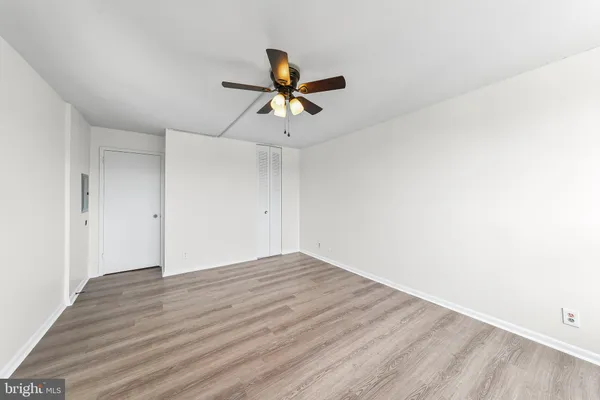 a view of a room with wooden floor and a ceiling fan
