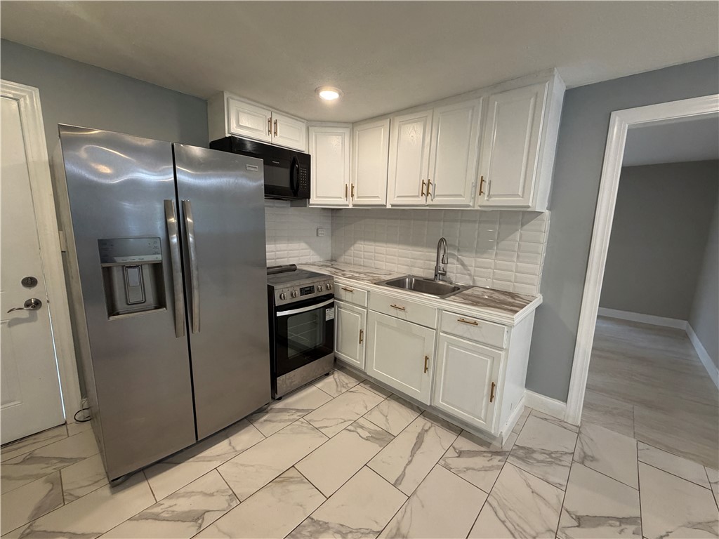 302 Sirrine Street Honea Path, SC 29654 - Photo 7 of 24 A well-appointed kitchen features stainless steel appliances and abundant white cabinetry, offering both style and utility.