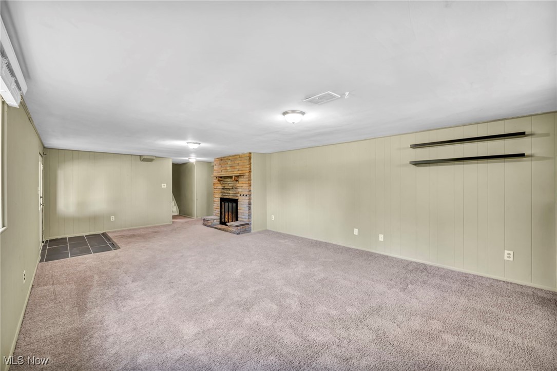 4523 Oakes Road Brecksville, OH 44141 - Photo 34 of 50 Unfurnished living room with a brick fireplace, carpet floors, and wood walls