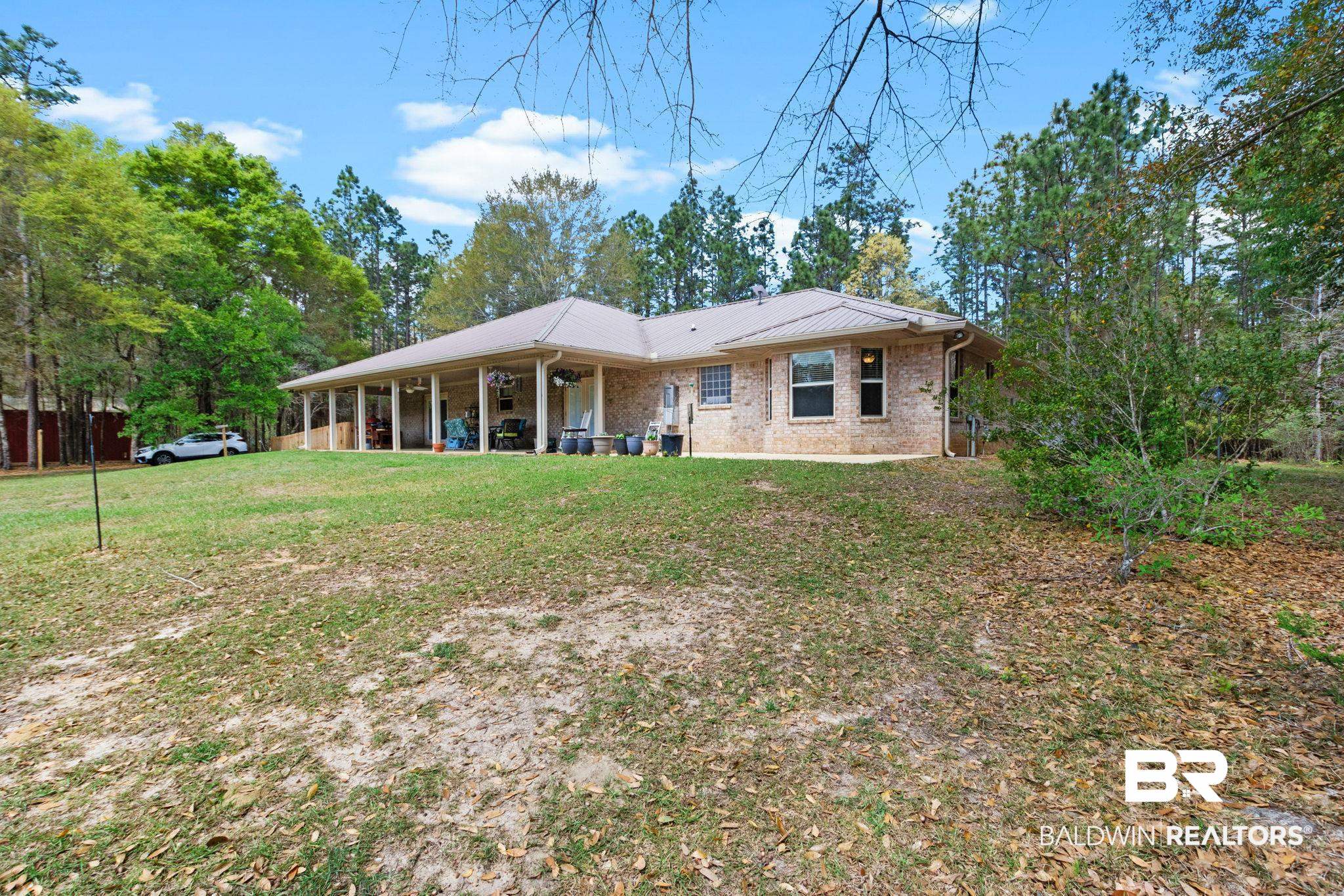 24250 Hack Road Bay Minette, AL 36507 - Photo 60 of 88 Rear view of property featuring a yard, brick siding, a patio, and a metal roof