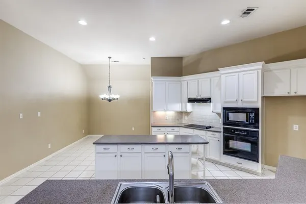 a kitchen with kitchen island cabinets and appliances