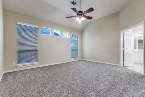 an empty room with windows and fan