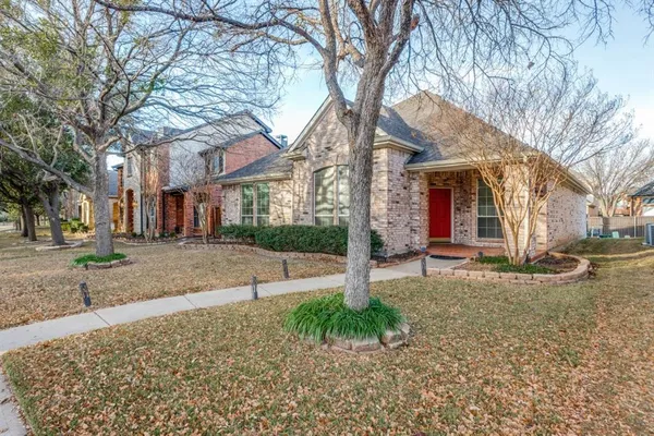a view of a house with a yard and large tree
