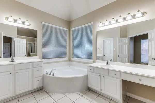 a spacious bathroom with a double vanity sink mirror and bathtub
