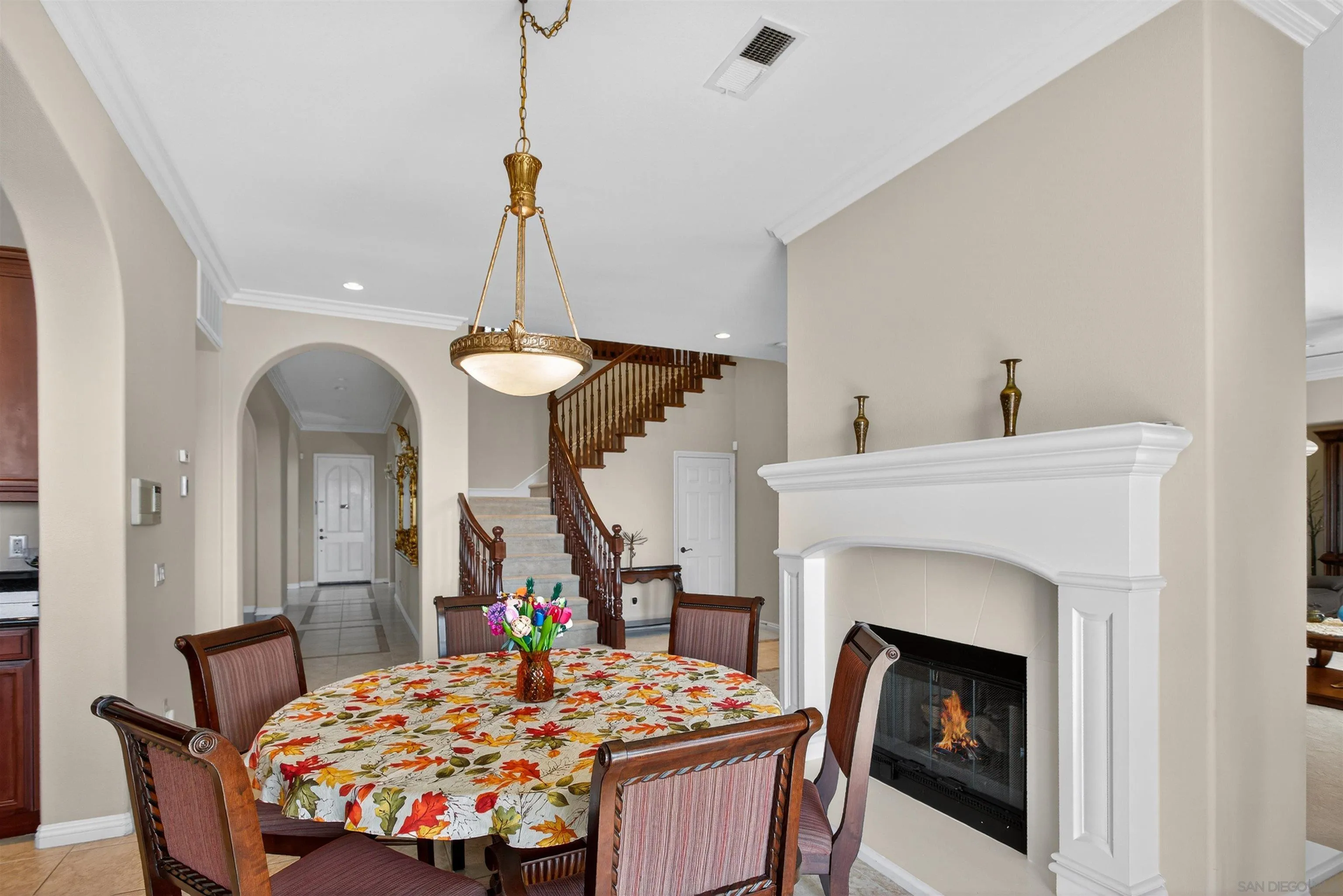 18410 Lakepointe Drive Riverside, CA 92503 - Photo 23 of 73 a living room with a fireplace a dining table and a chandelier