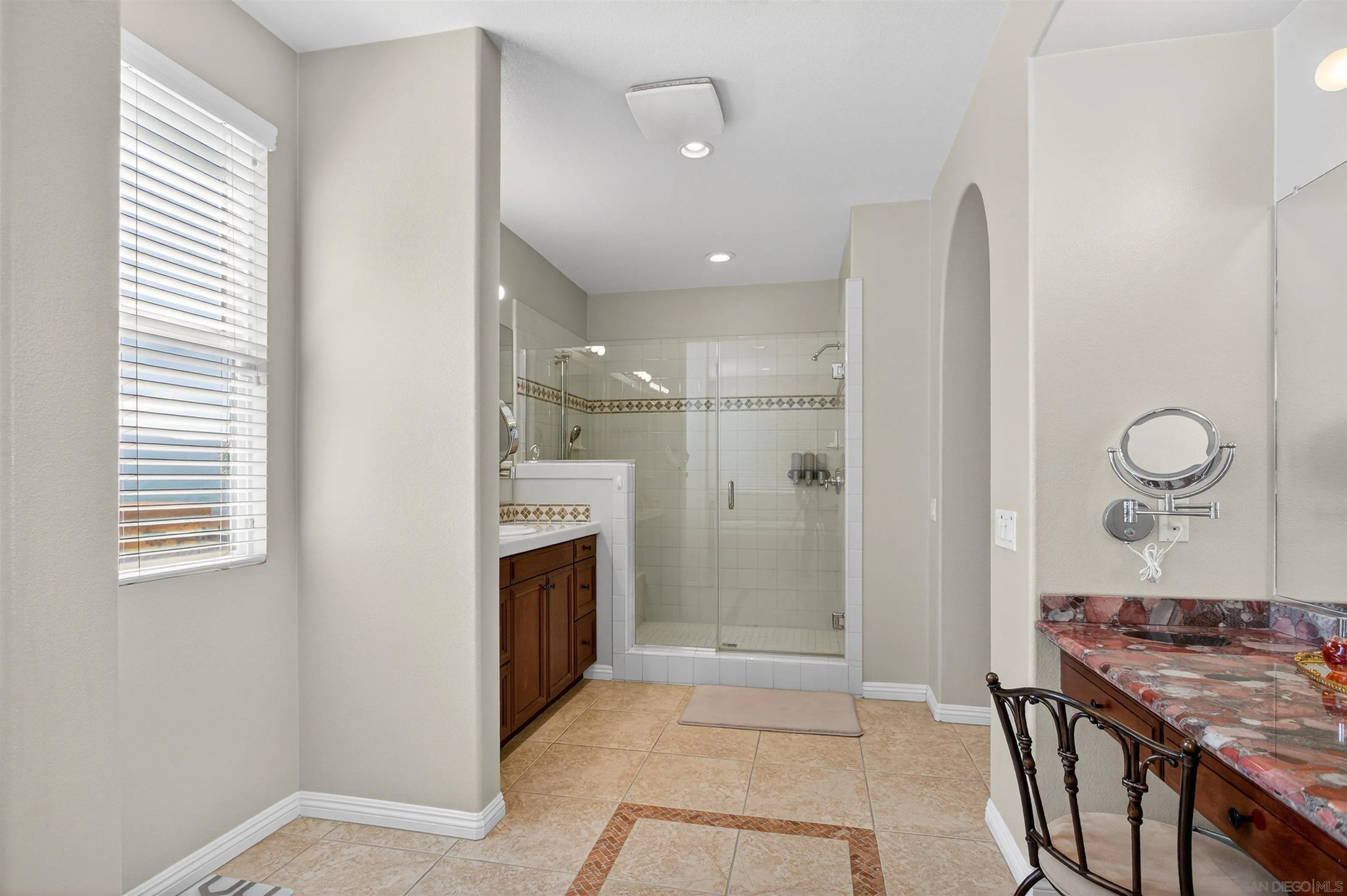 18410 Lakepointe Drive Riverside, CA 92503 - Photo 44 of 73 a bathroom with a granite countertop sink a mirror and a shower