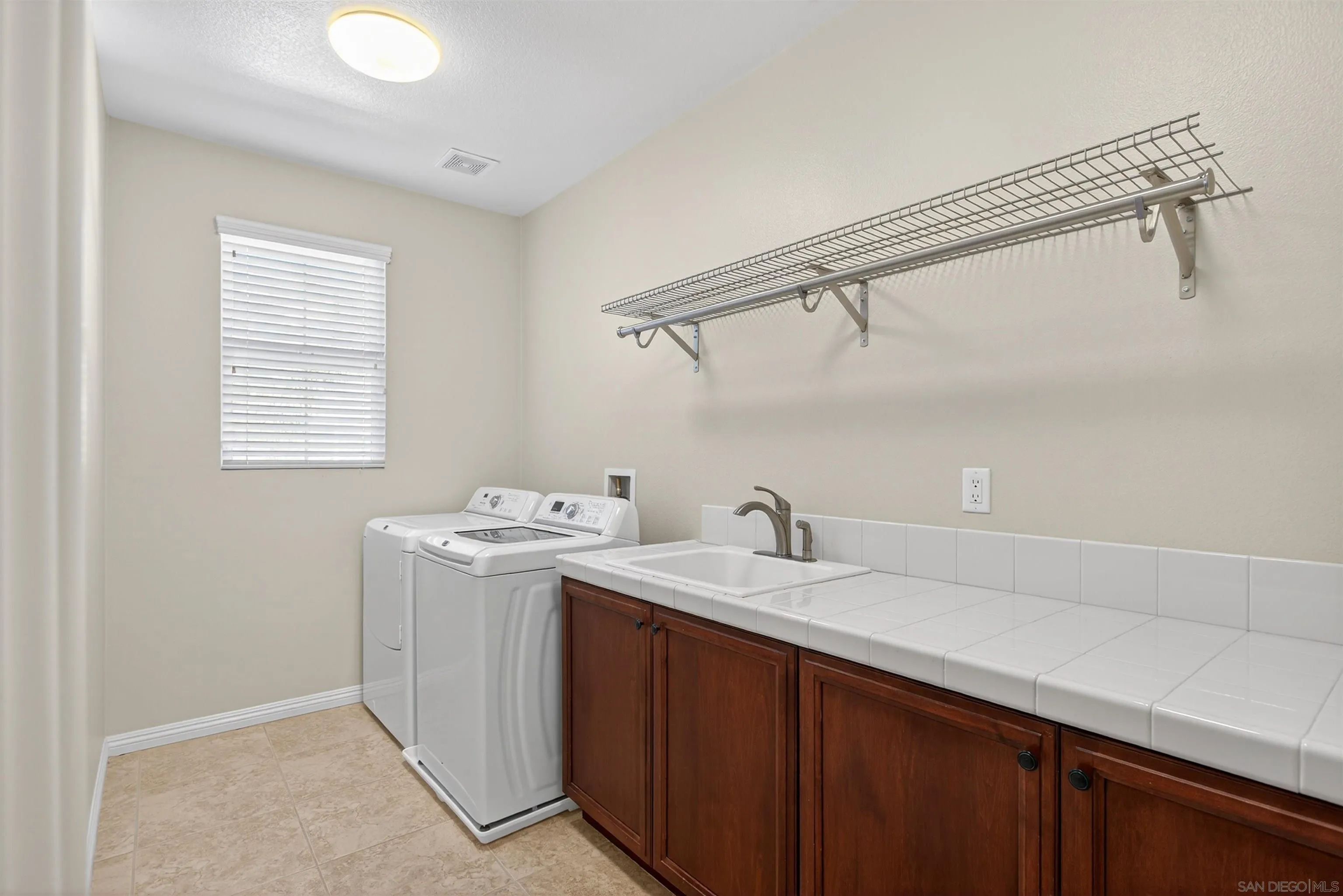 18410 Lakepointe Drive Riverside, CA 92503 - Photo 50 of 73 a utility room with a sink a cabinetry and appliances