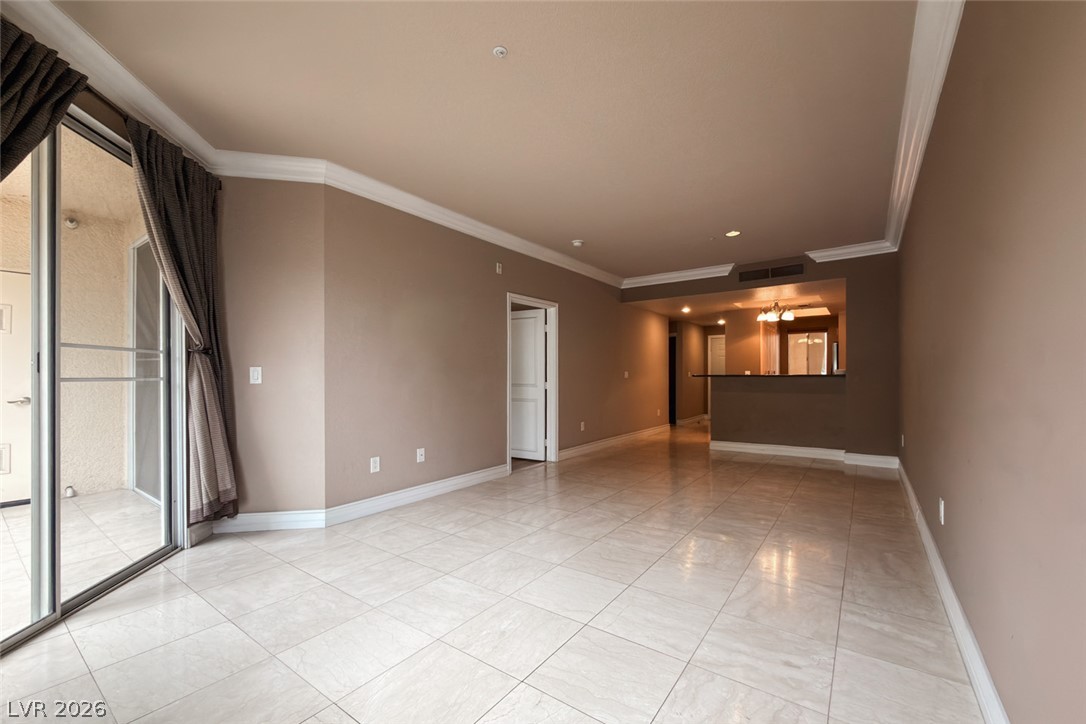 210 East Flamingo Road, Unit 112 Las Vegas, NV 89169 - Photo 1 of 59 Polished tile flooring and elegant crown molding frame a spacious, open living area.