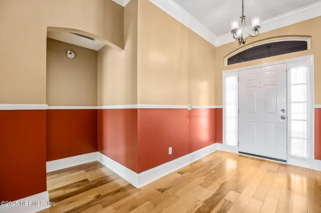 a view of a livingroom with a chandelier fan and windows