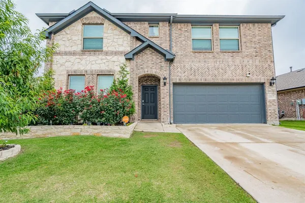 a front view of a house with a garden and yard