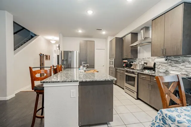 a kitchen with stainless steel appliances granite countertop a sink stove and refrigerator