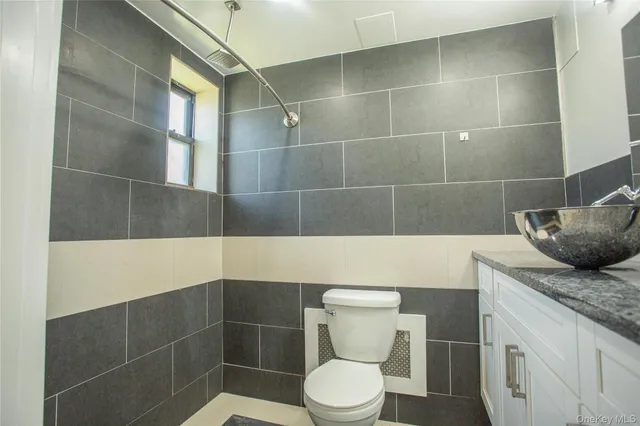 a bathroom with a granite countertop toilet a sink and shower