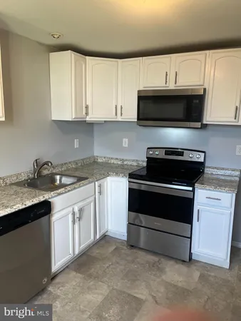 a kitchen with stainless steel appliances granite countertop a stove and a microwave