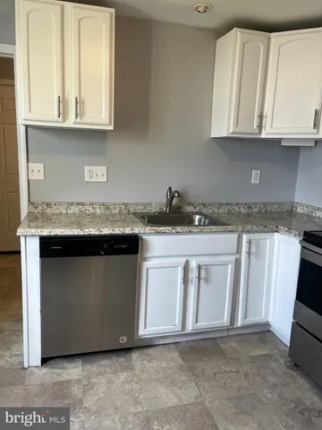 a kitchen with granite countertop a sink and cabinets