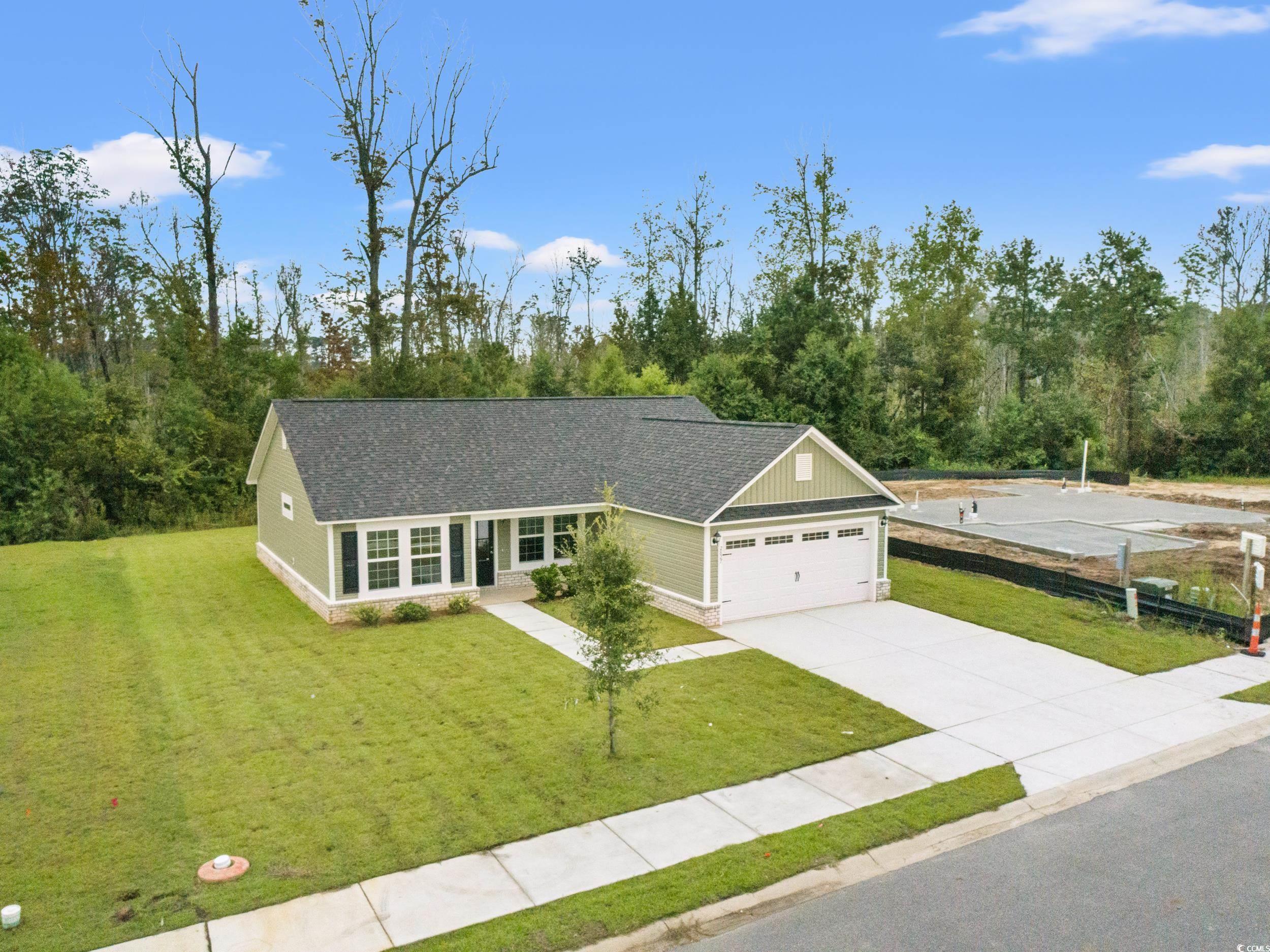 2827 Biscane Court Conway, SC 29527 - Photo 25 of 31 View of front of house featuring a front yard, a shingled roof, driveway, an attached garage, and board and batten siding