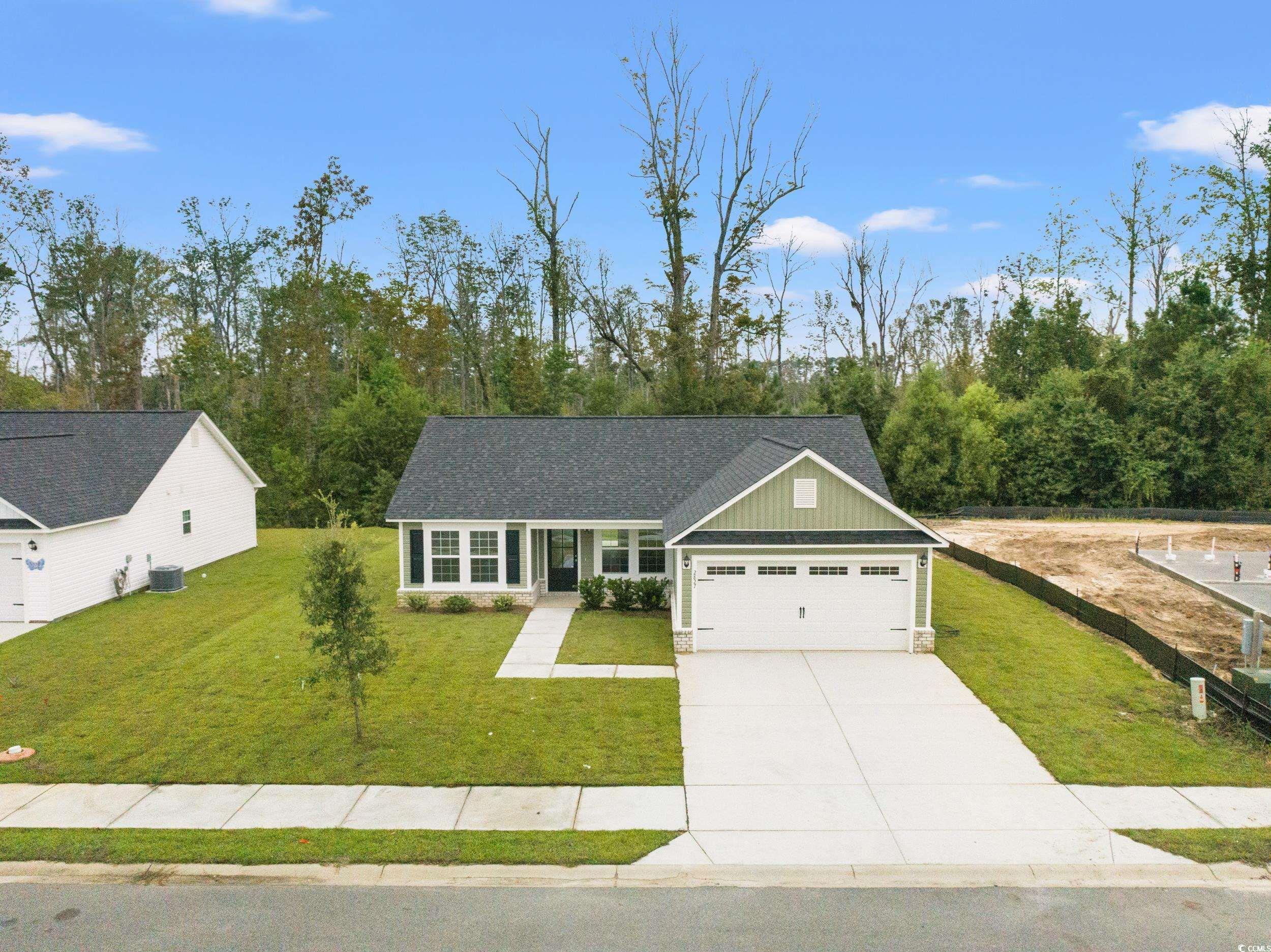 2827 Biscane Court Conway, SC 29527 - Photo 26 of 31 View of front of house featuring board and batten siding, a front yard, driveway, an attached garage, and roof with shingles